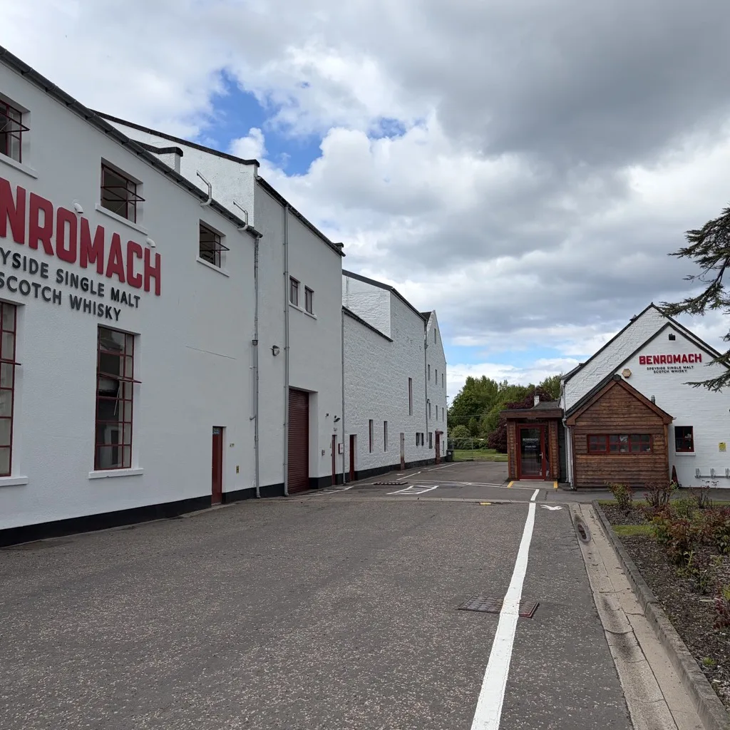 The facade of Benromach Distillery in Forres with red lettering