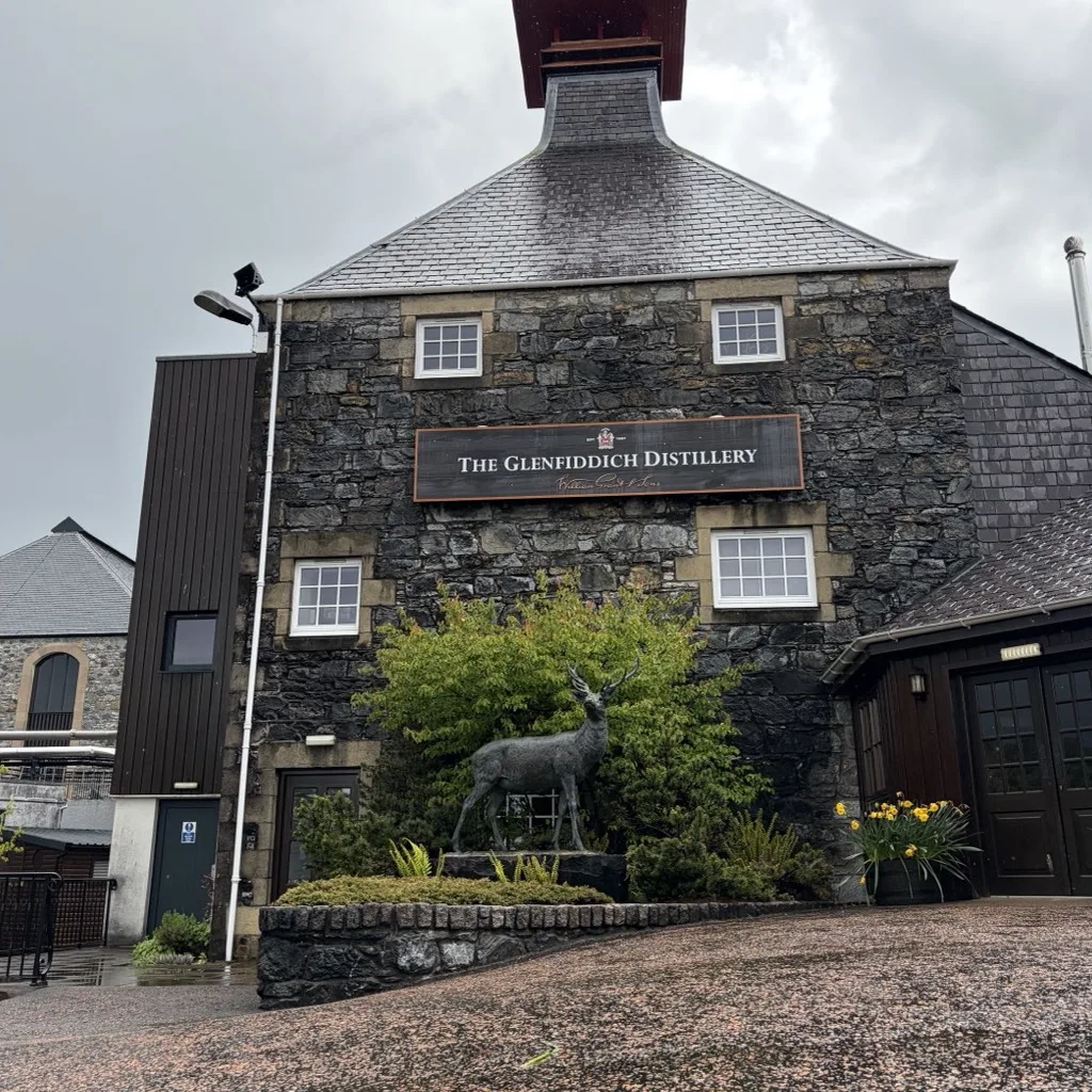 The visitor centre of Glenfiddich Distillery in Dufftown with a bronze stag statue